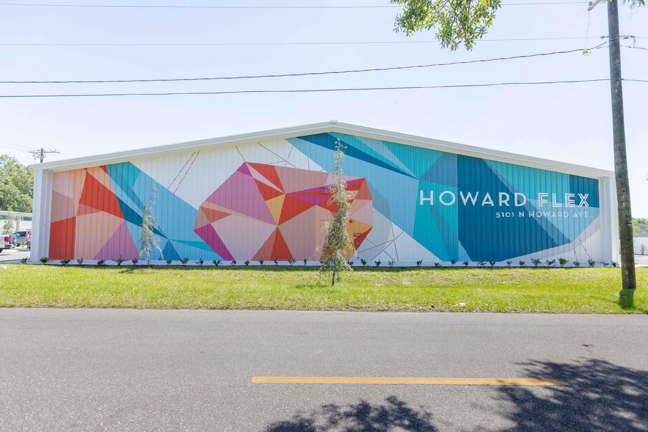 Howard Flex building mural with geometric jewel shapes and painted address graphics, Tampa